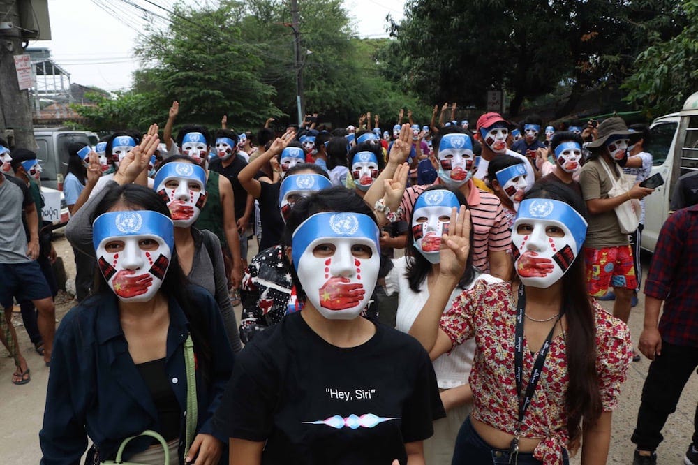 People in Myanmar wearing masks symbolizing the silencing of dissent