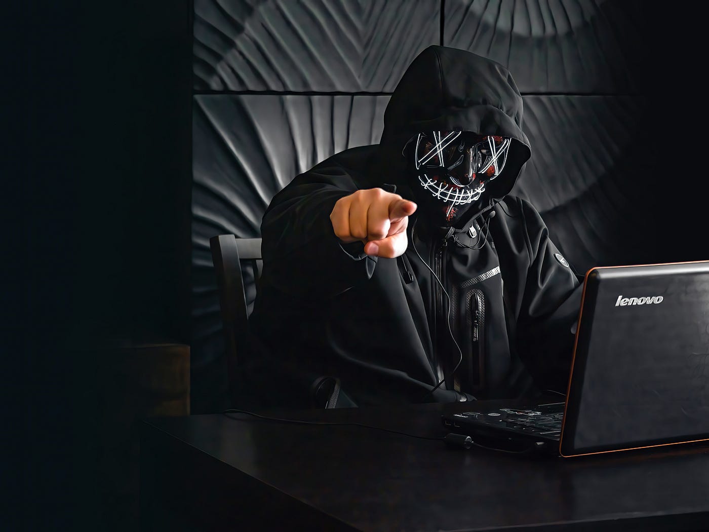 IMAGE: A person in a hoodie in black and white pointing at the camera with a hand in color.