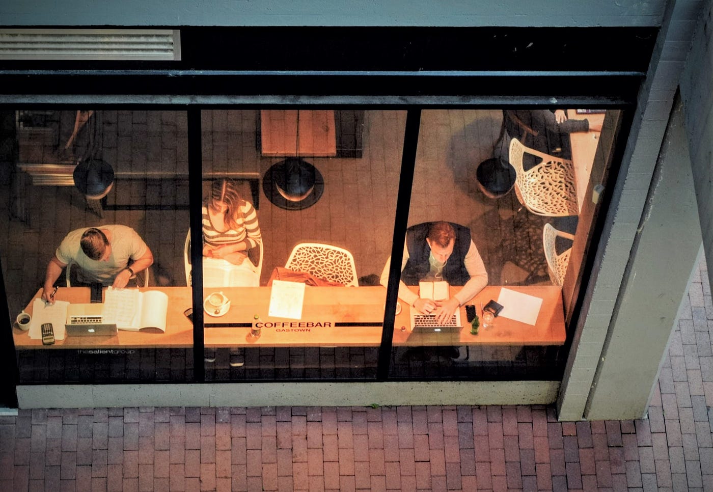 birdseye view through large windows of people working at common desk
