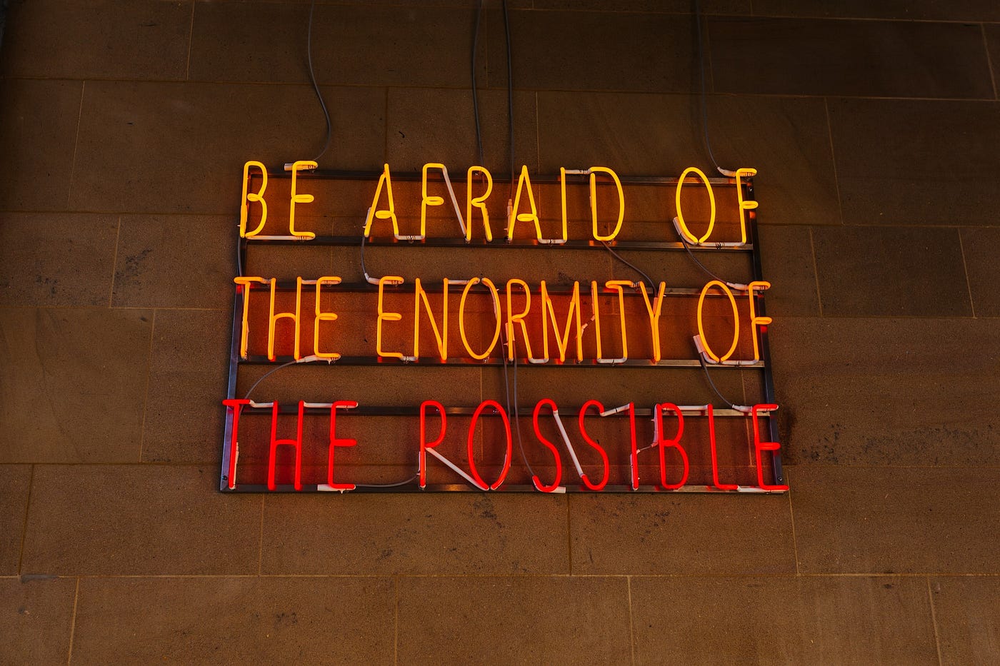 Neon sign that says, Be Afraid of the Enormity of the Possible