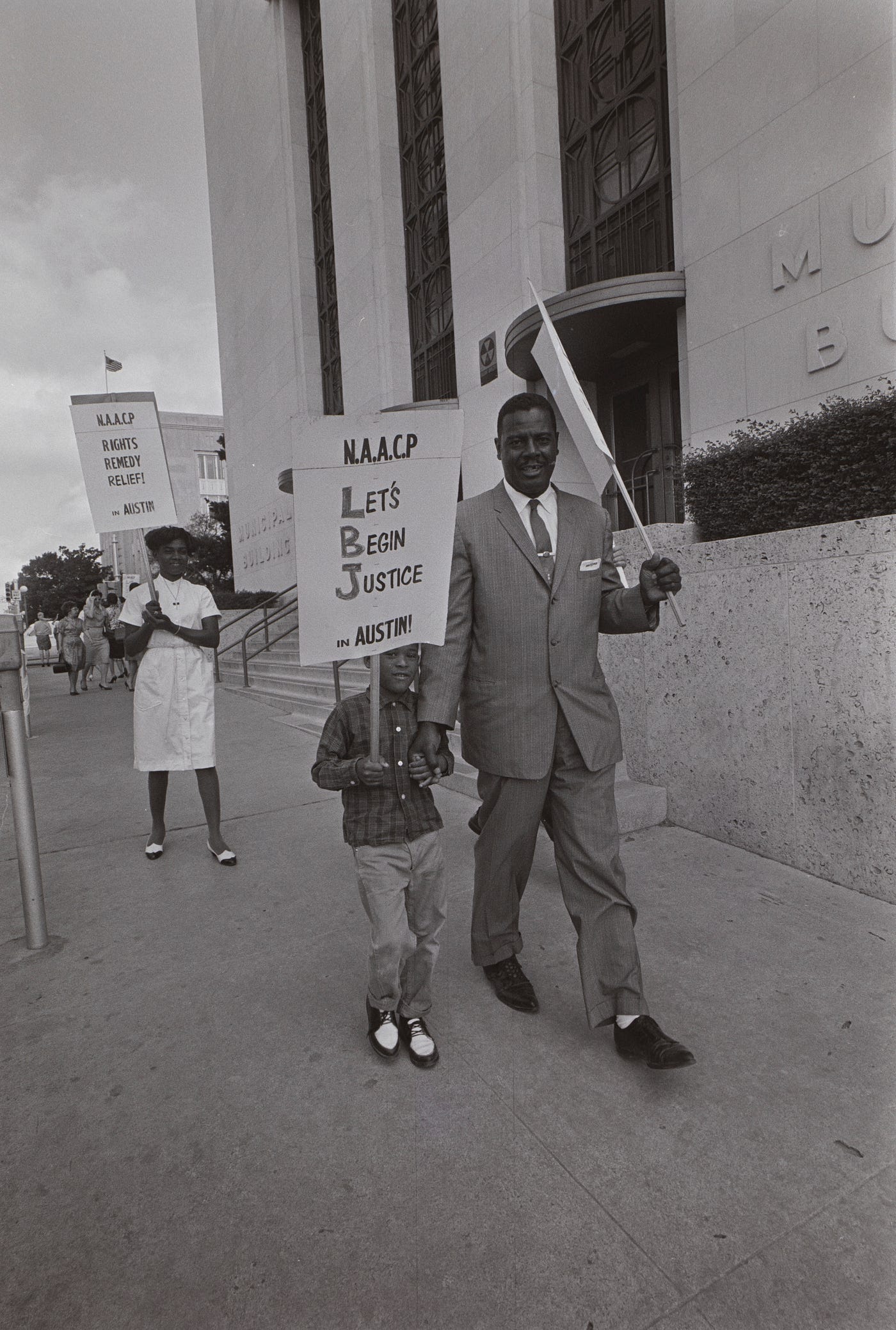 Protesters carry signs outside Austin city hall in 1964.