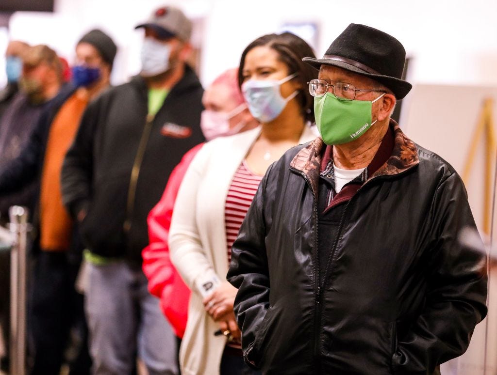 Voters wearing face masks in line at the polls.