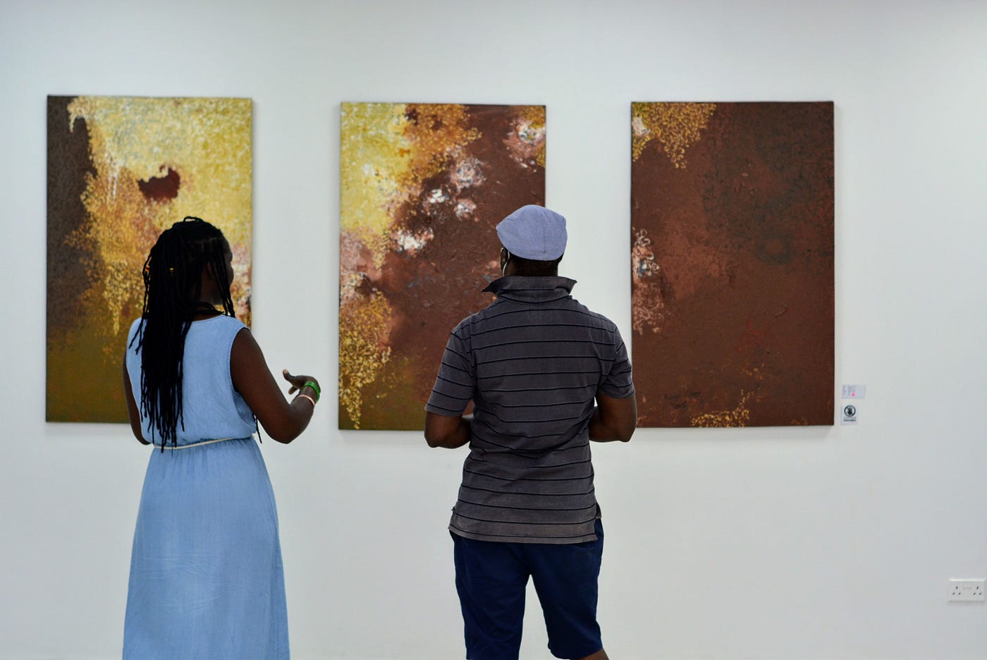 Mulenga J. Mulenga explaining an abstract piece of painting to a guest at her exhibition