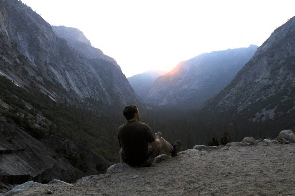 A man rests on a mountain vista