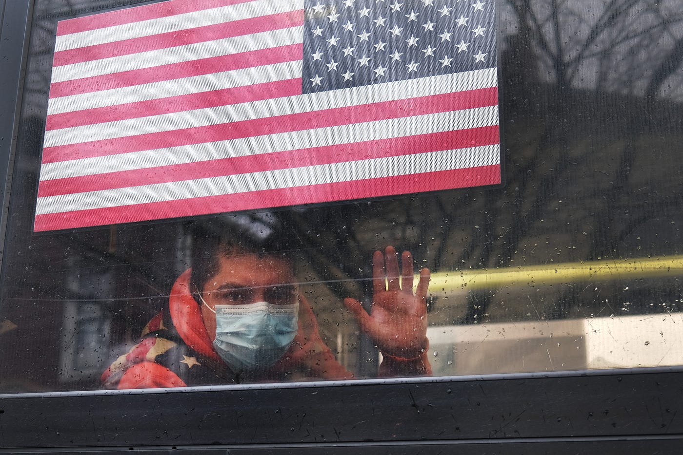 A man waves from a bus in a neighborhood in the Queens borough, which has one of the highest infection rates of coronavirus.
