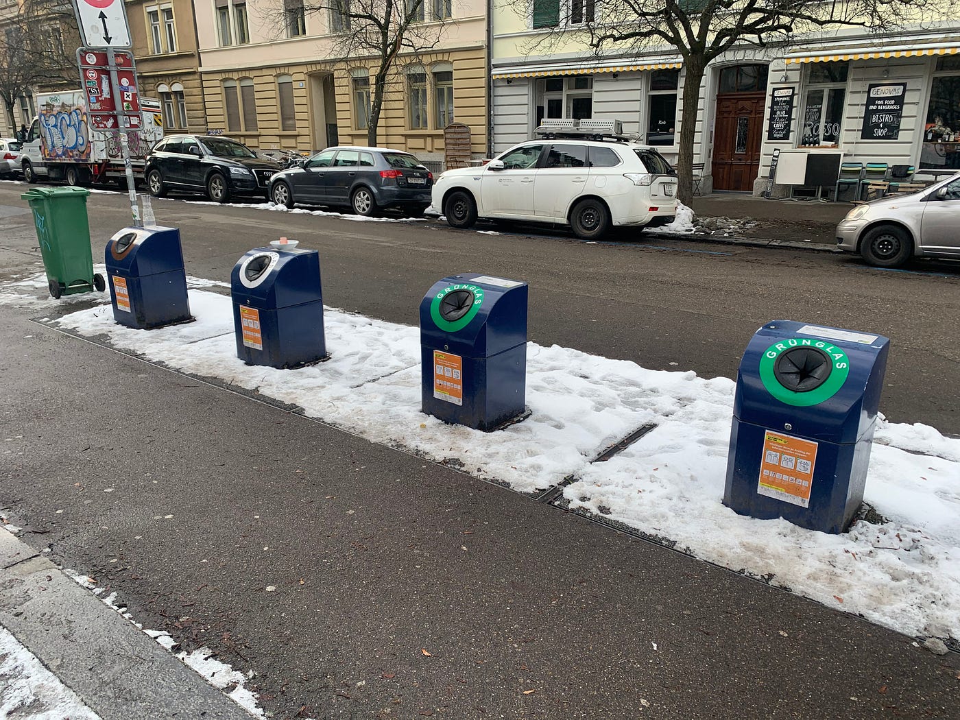 Four blue recycling bins: brown glass, white glass, and two for green glass
