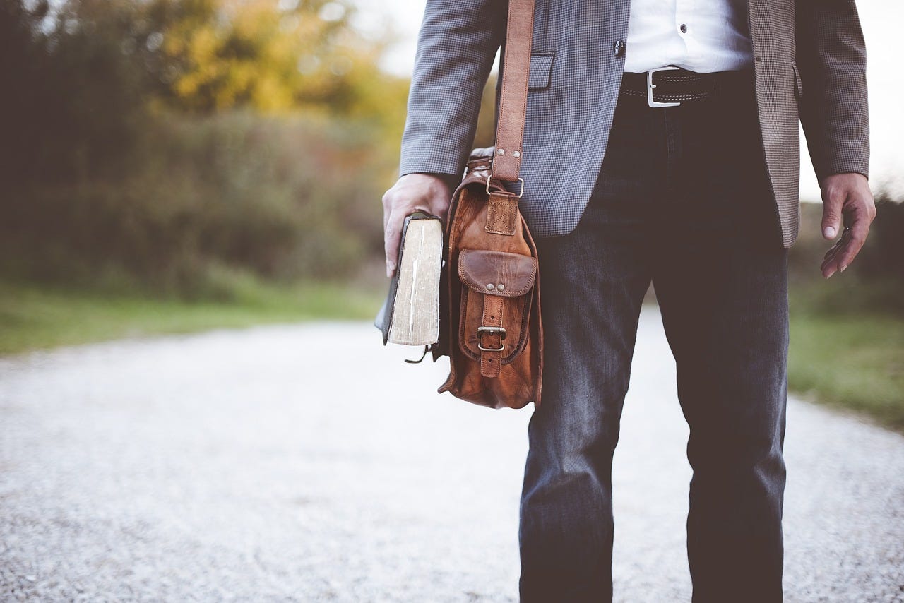 A picture of a trendy chap walking along a road. He’s carrying a book and a satchel. I’m guessing his name is Tarquin.