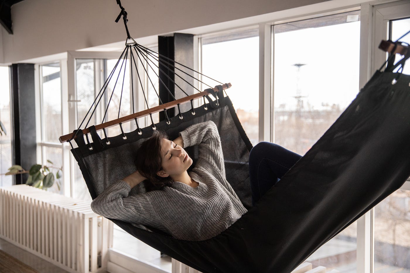 Young woman resting in a hammock at home
