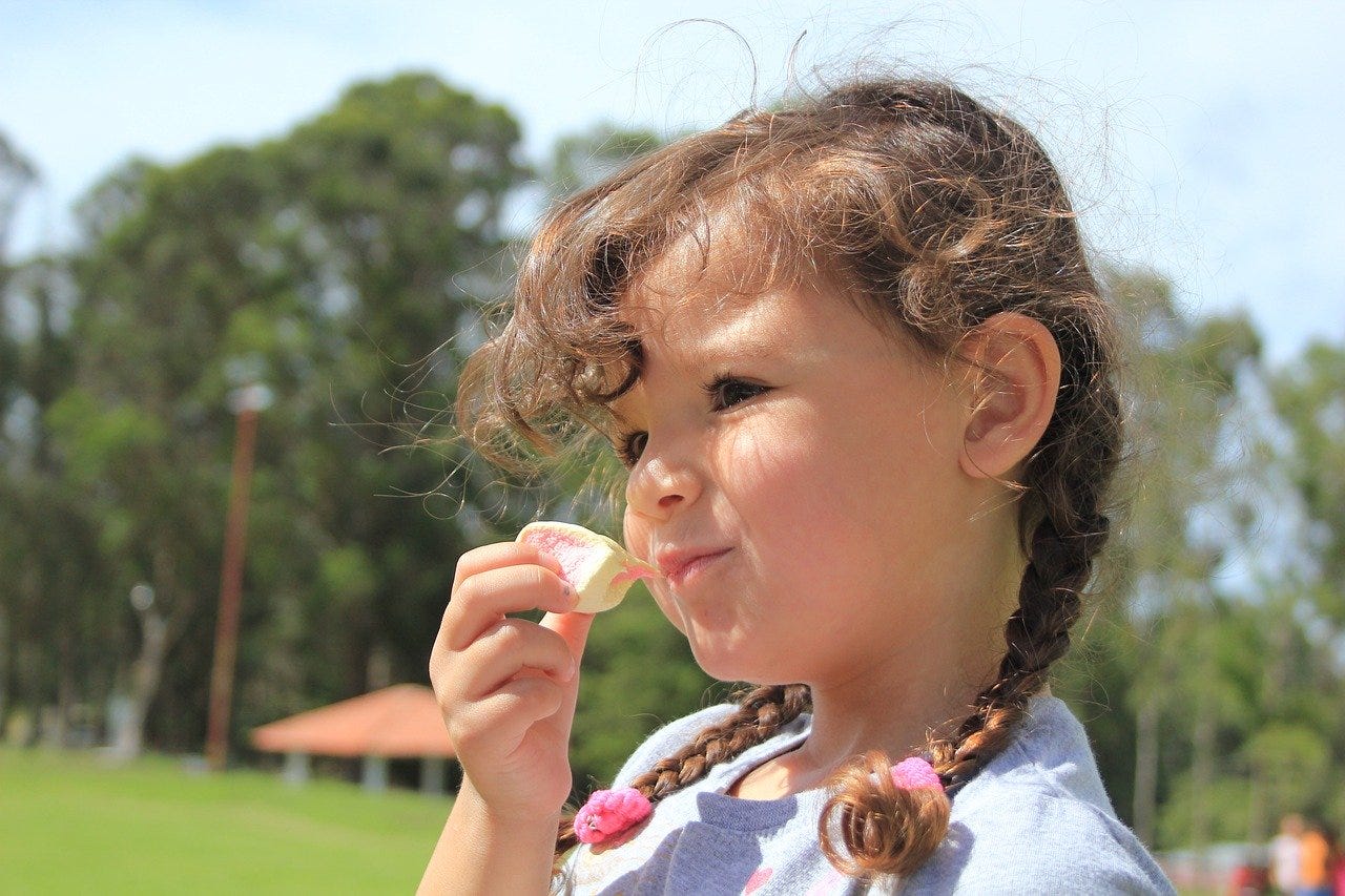 menina comendo marshmallow