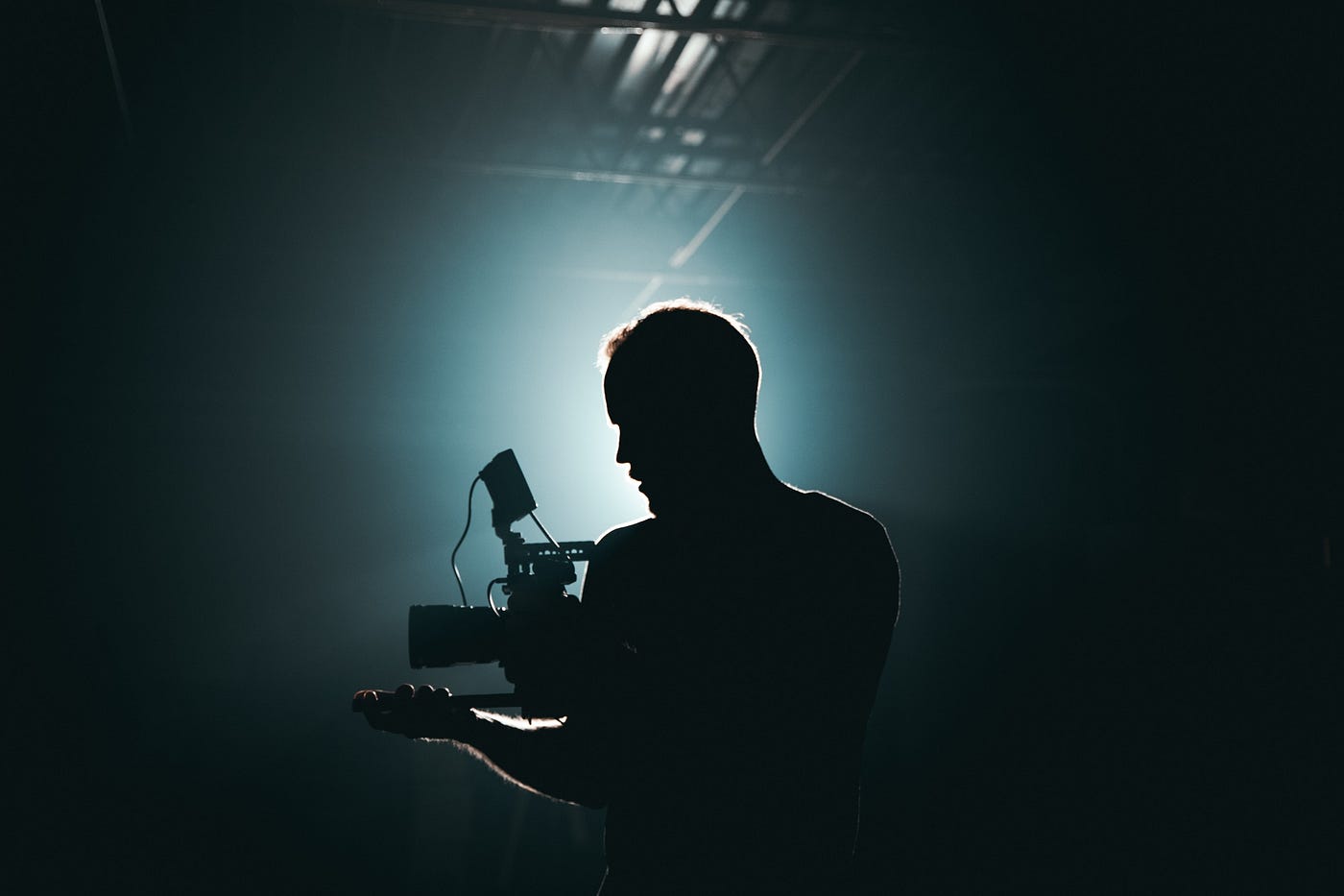 A man holding a video camera in the dark