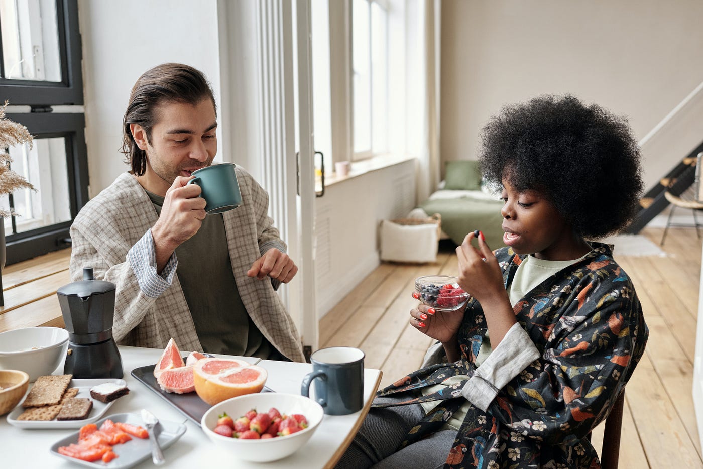 Man and a woman at a table eating breakfast