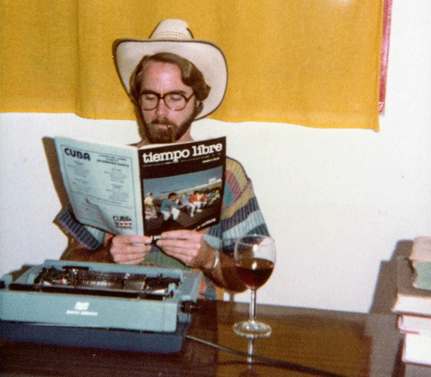Bearded young writer taking a break with wine and a smoke.