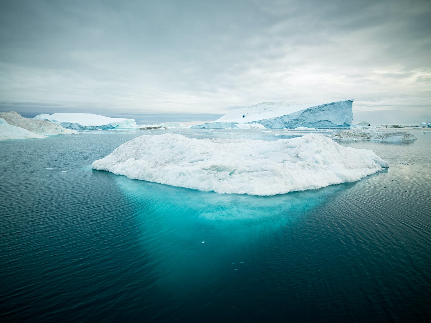 An iceberg on water, with the underwater part visible.