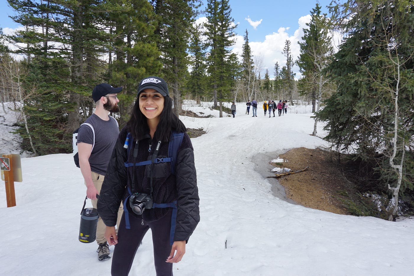 Lory heads a hike on a snowy trail featuring a group of people behind her and a guy next to her