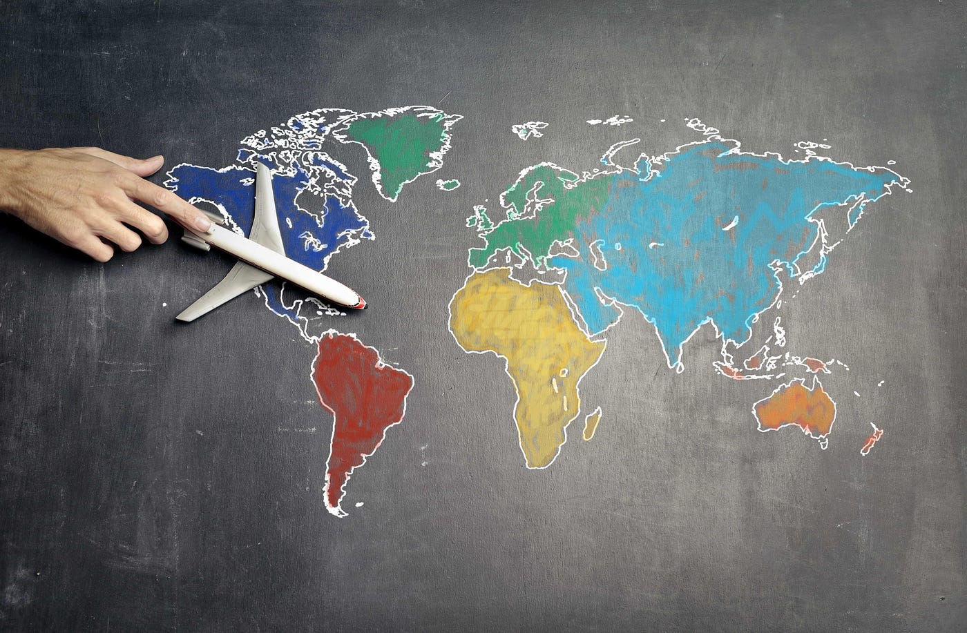 Model airplane sitting on a colorful map of the world.
