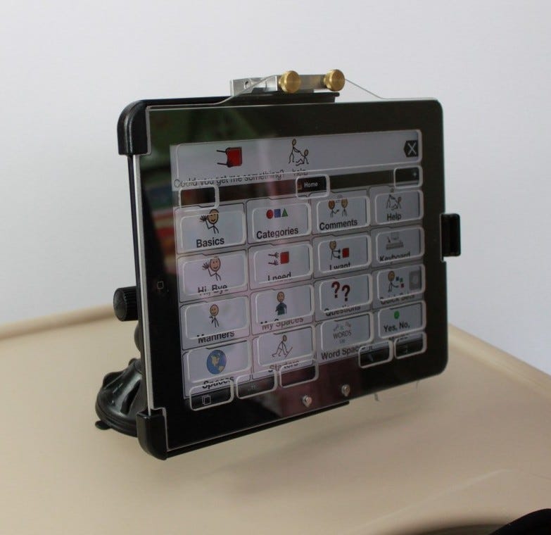 A keyguard over the top of an iPad, with Proloquo2Go on screen.