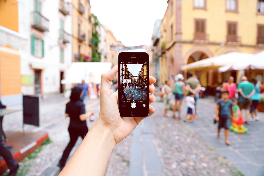 man holds up a phone to take a picture