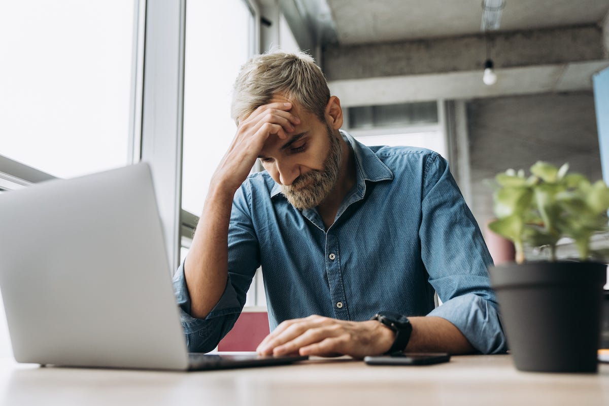 A male employee facepalms. Why? Because he procured an ill-fitting learning management system that is giving him problem after problem. He could’ve avoided these by reading Acorn’s 11 common problem guide.