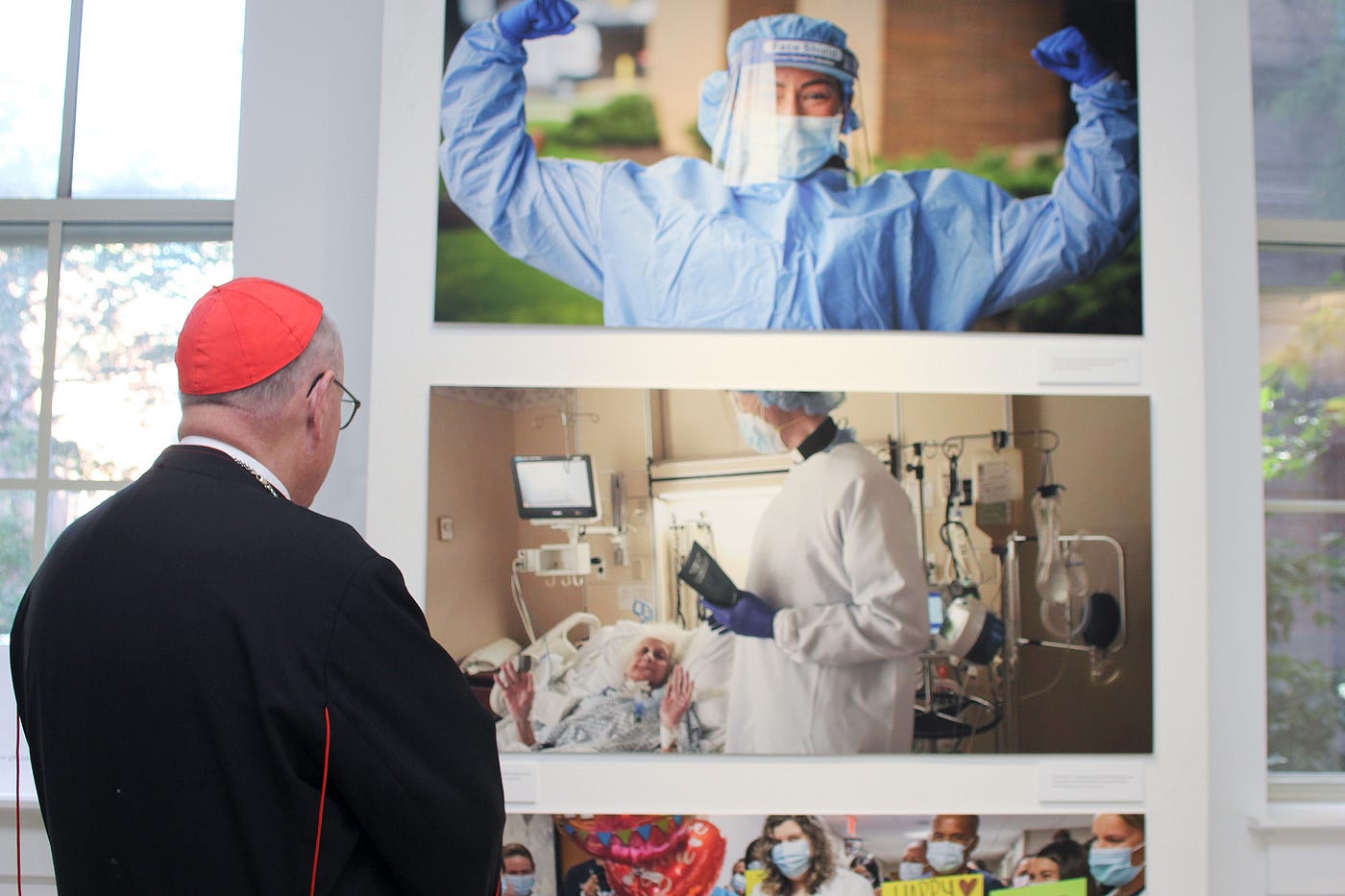 Cardinal Timothy Dolan views the photographs at the Portraits of Grace Exhibition at the Sheen Center.