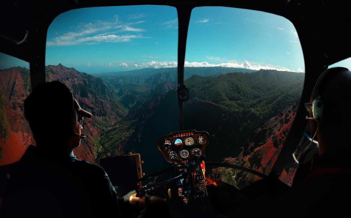 View of mountains and sky ahead as seen from cockpit of a small aircraft with controls in the center of the screen