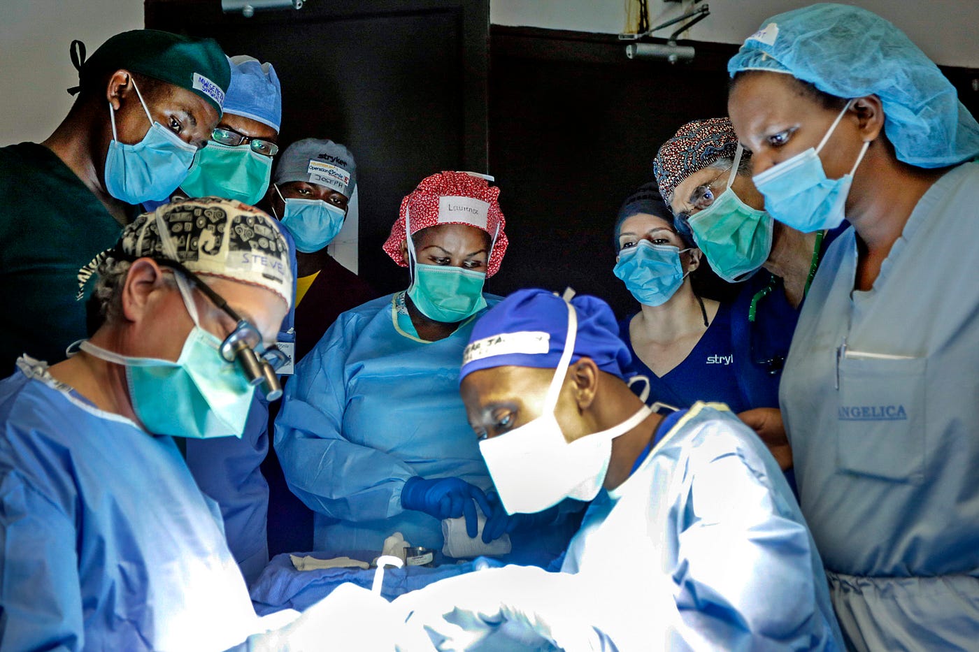Medical professionals observe a surgeon during an operation.