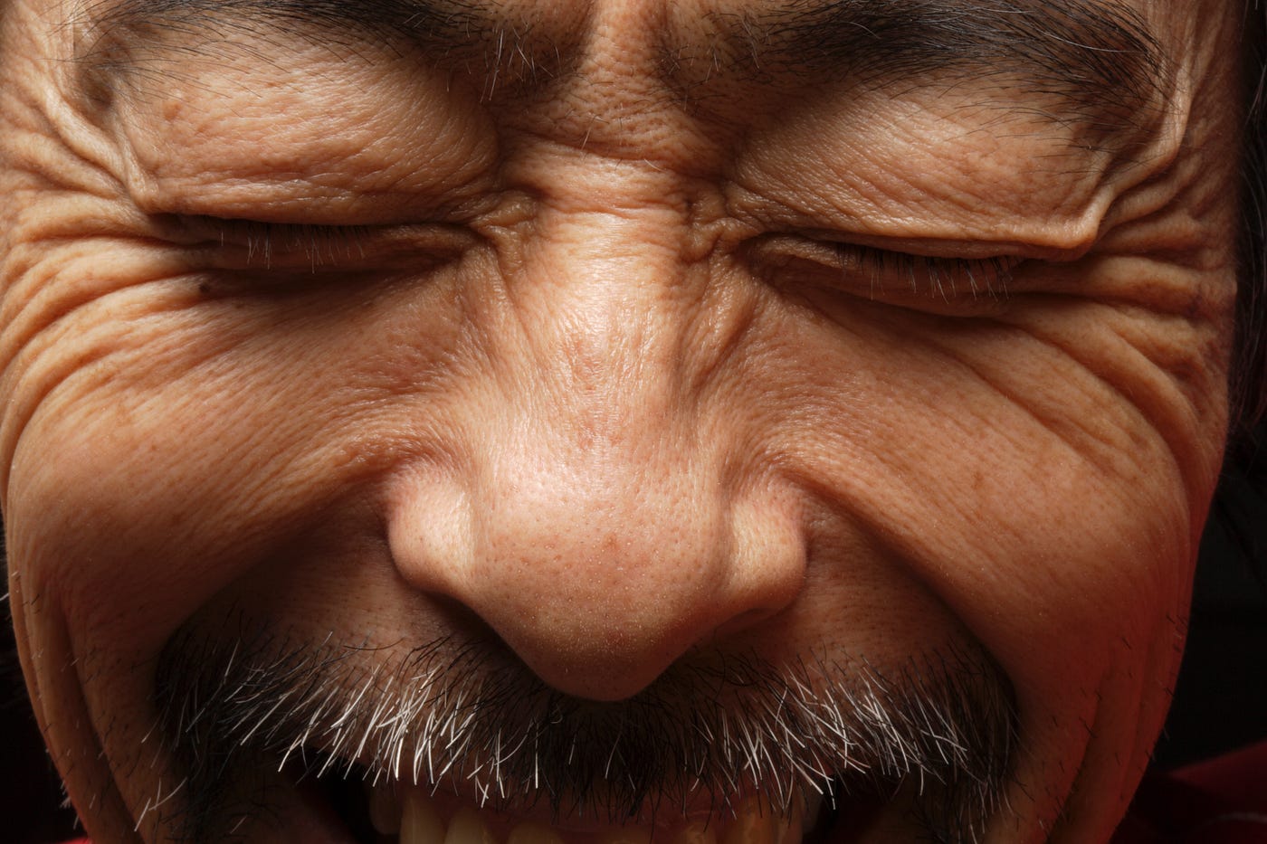 Close up of a man smiling with his eyes closed.
