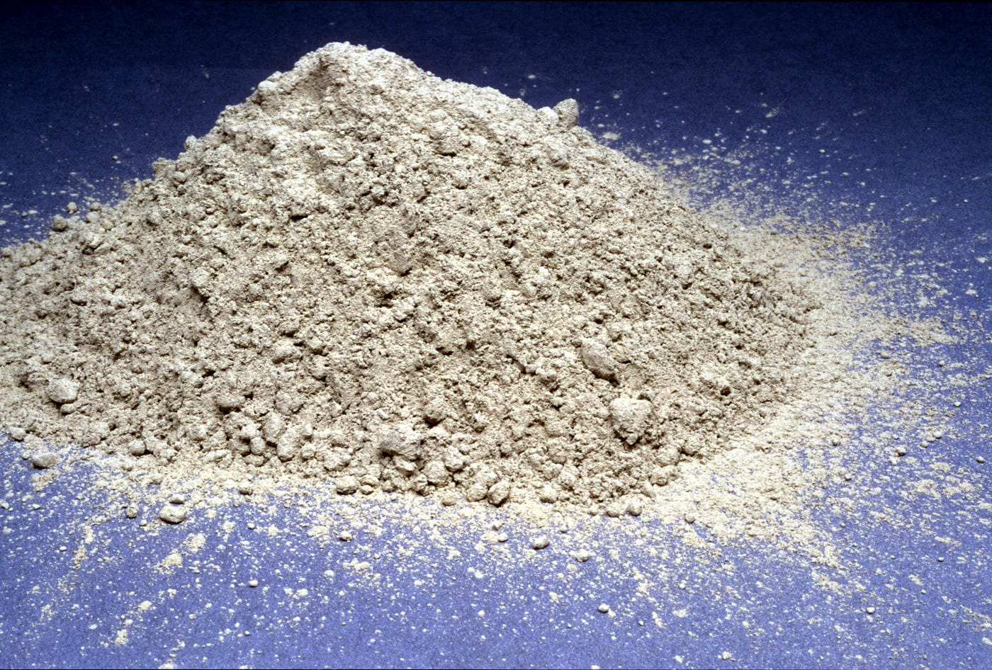 A pile of cement is sitting on a blue floor.