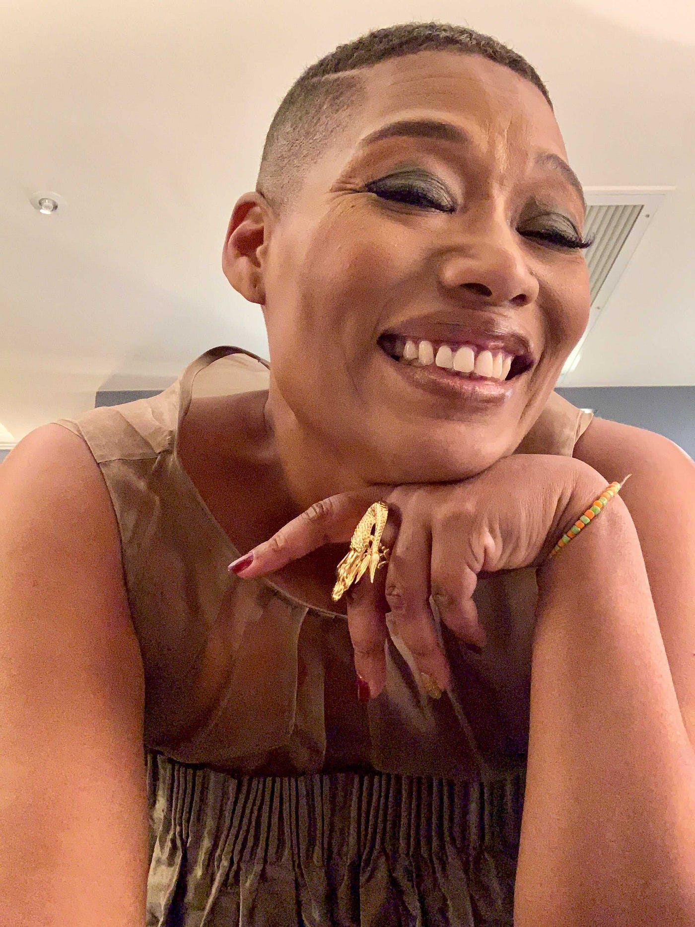 A selfie of Joan Morgan smiling while wearing smoky eye makeup.