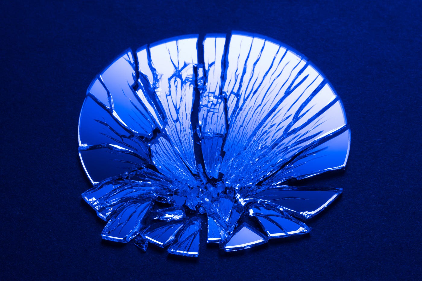 A blue-tinted photo of a shattered mirror.
