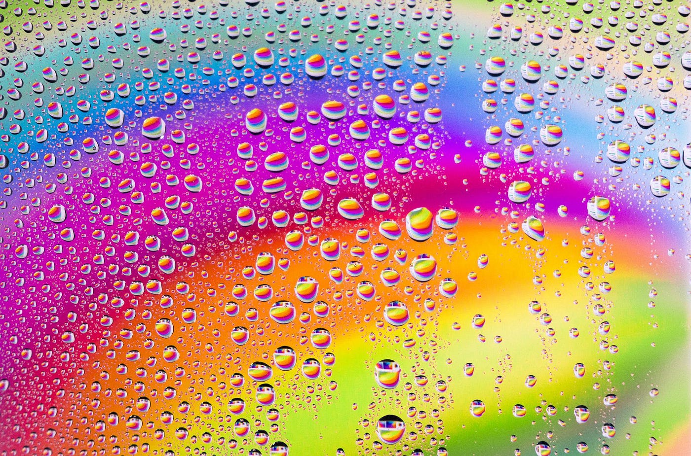 A rainbow background covered with water droplets.
