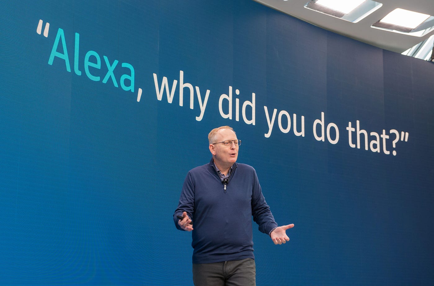 Amazon senior VP Dave Limp demonstrates a new Alexa feature. The text “Alexa, why did you do that?” is showcased behind him.