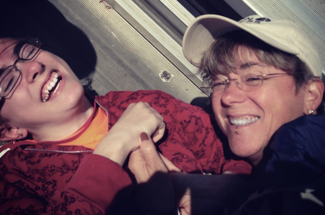 a giggling girl and her sporty laughing mom in the bleachers