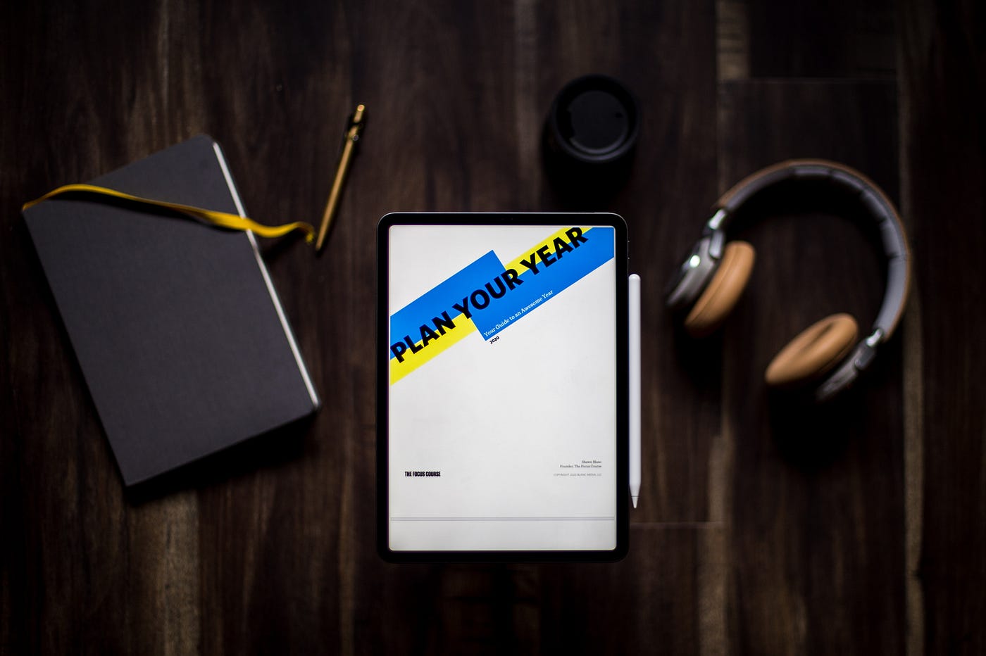 A journal, calendar, and headphones sitting on a table.