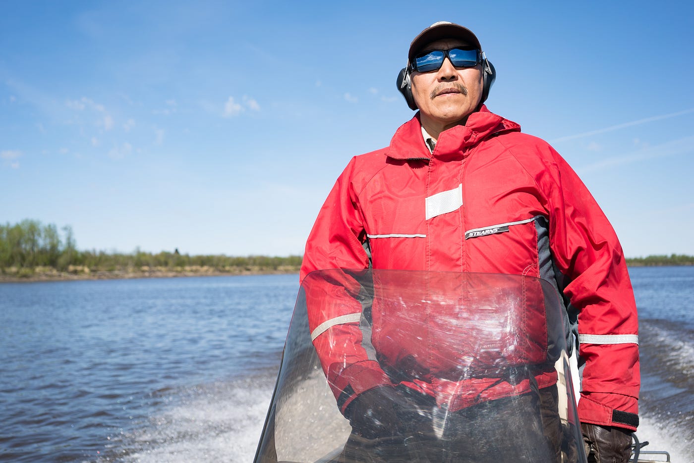 Photo of Christopher Tulik, Yup’ik, driving a boat and looking forward.