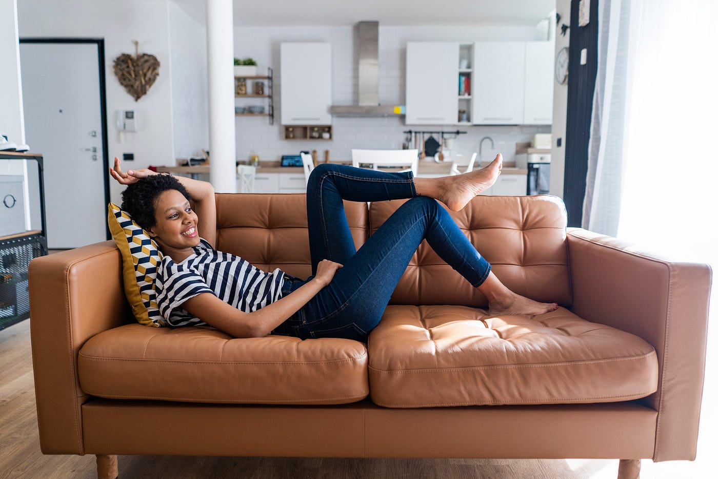 Black woman relaxing at home on her sofa.
