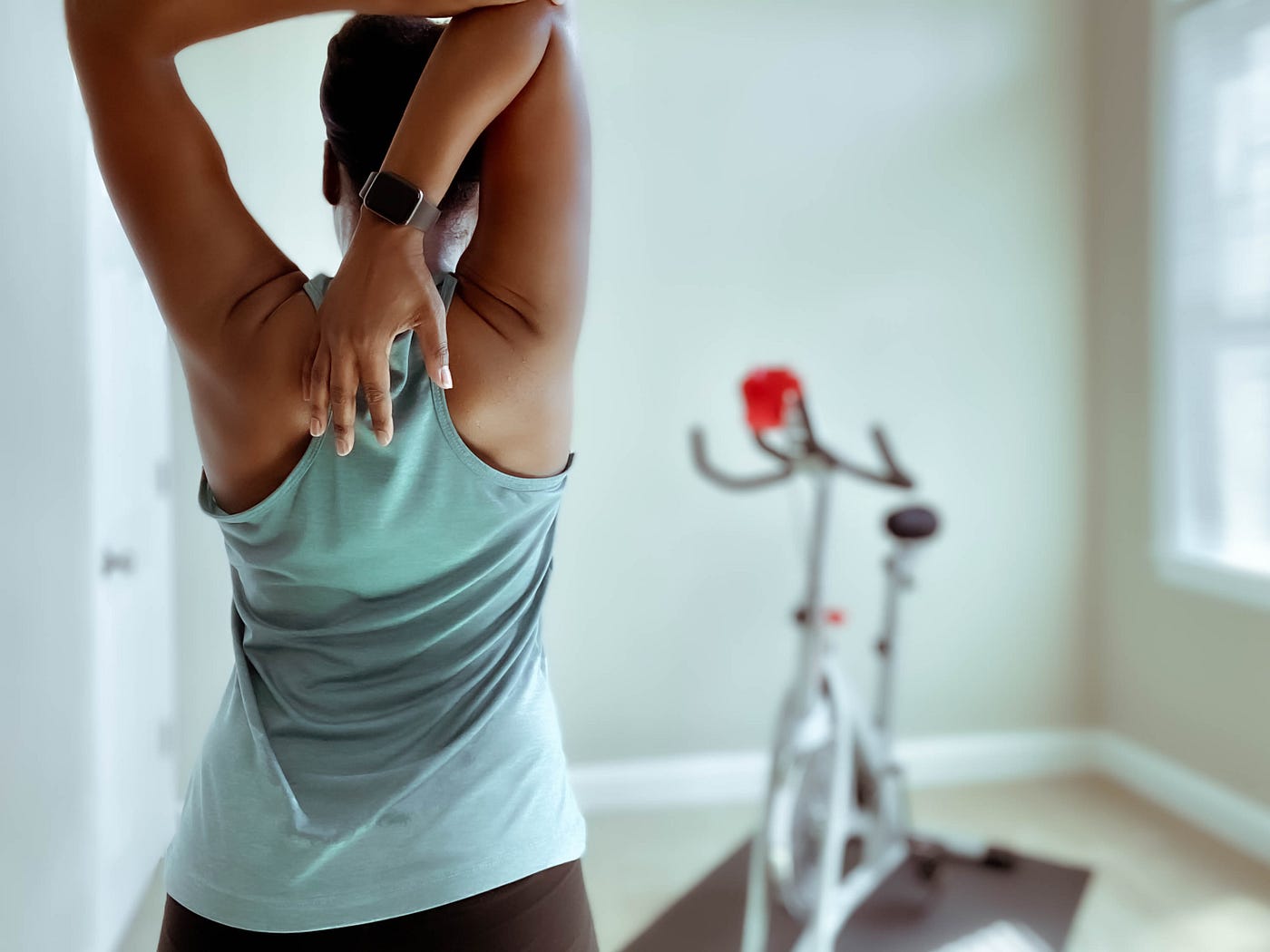 A woman stretching while wearing a smartwatch.