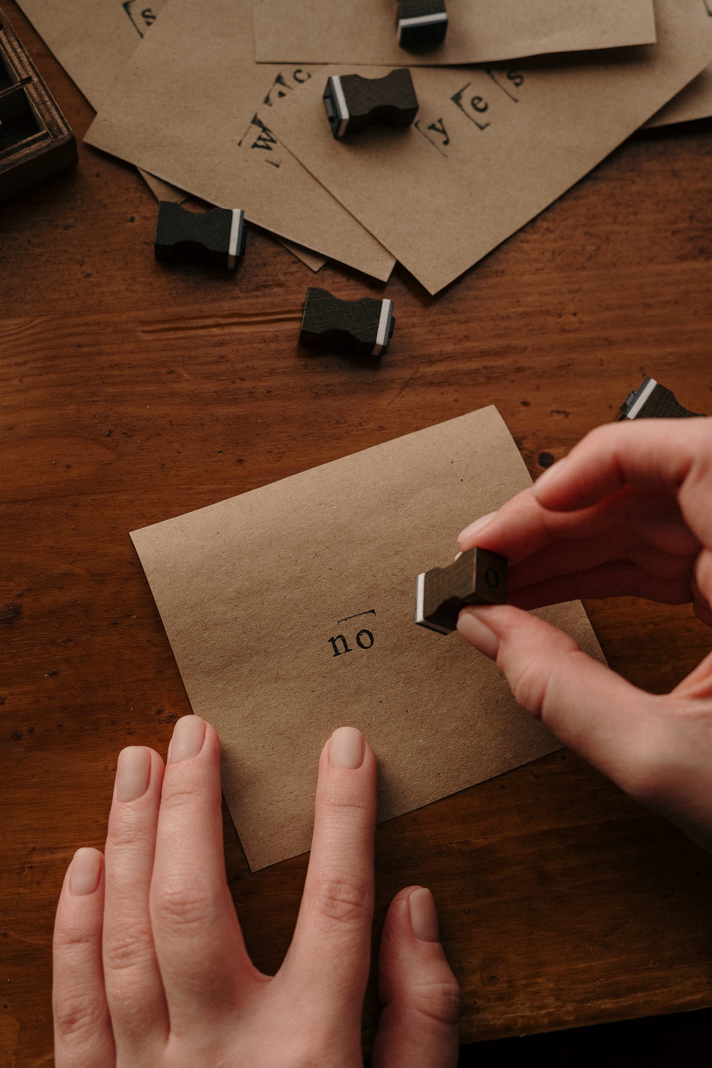 A girl is stamping the word NO on the paper.