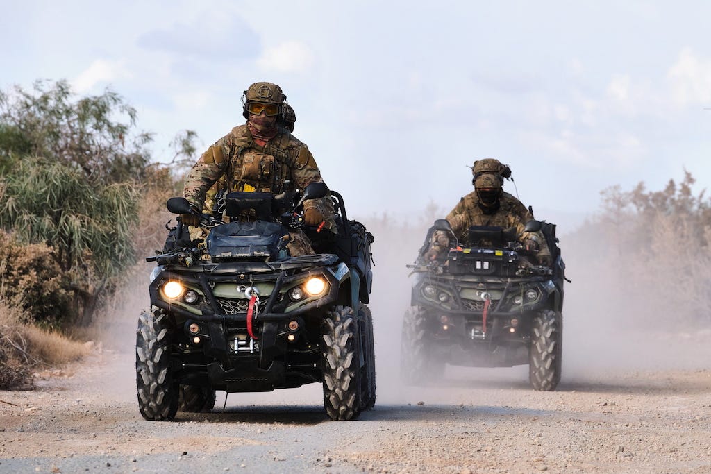 An image of Royal Marine soldiers riding quad bikes.