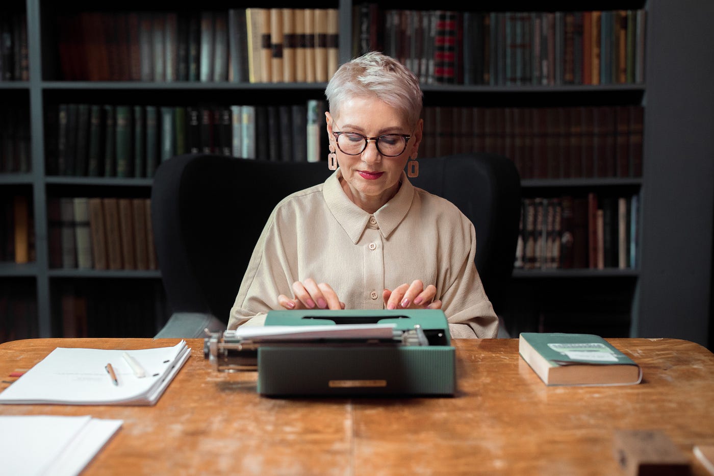 woman sitting at table using typewriter