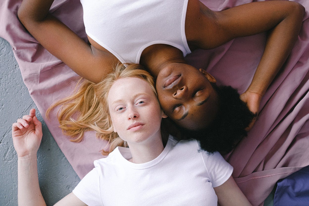 Two white and black women on the floor.