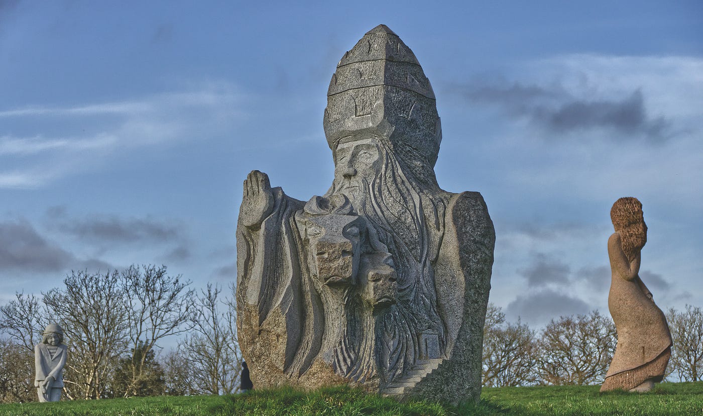 Sculpture de « Korneli » réalisée par l’artiste Goulven Jaouen. Saint Cornély, Sant Korneli en breton, est le plus connu des saints protecteurs du bétail. Selon la légende, Cornély, pape à Rome, était poursuivi par des soldats païens. Deux bœufs l’accompagnaient qui portaient ses bagages. Un soir, il arriva devant la mer. Les soldats le serraient de près, rangés en bataille. Il se cacha dans l’oreille d’un bœuf et transforma ses ennemis en pierre.
