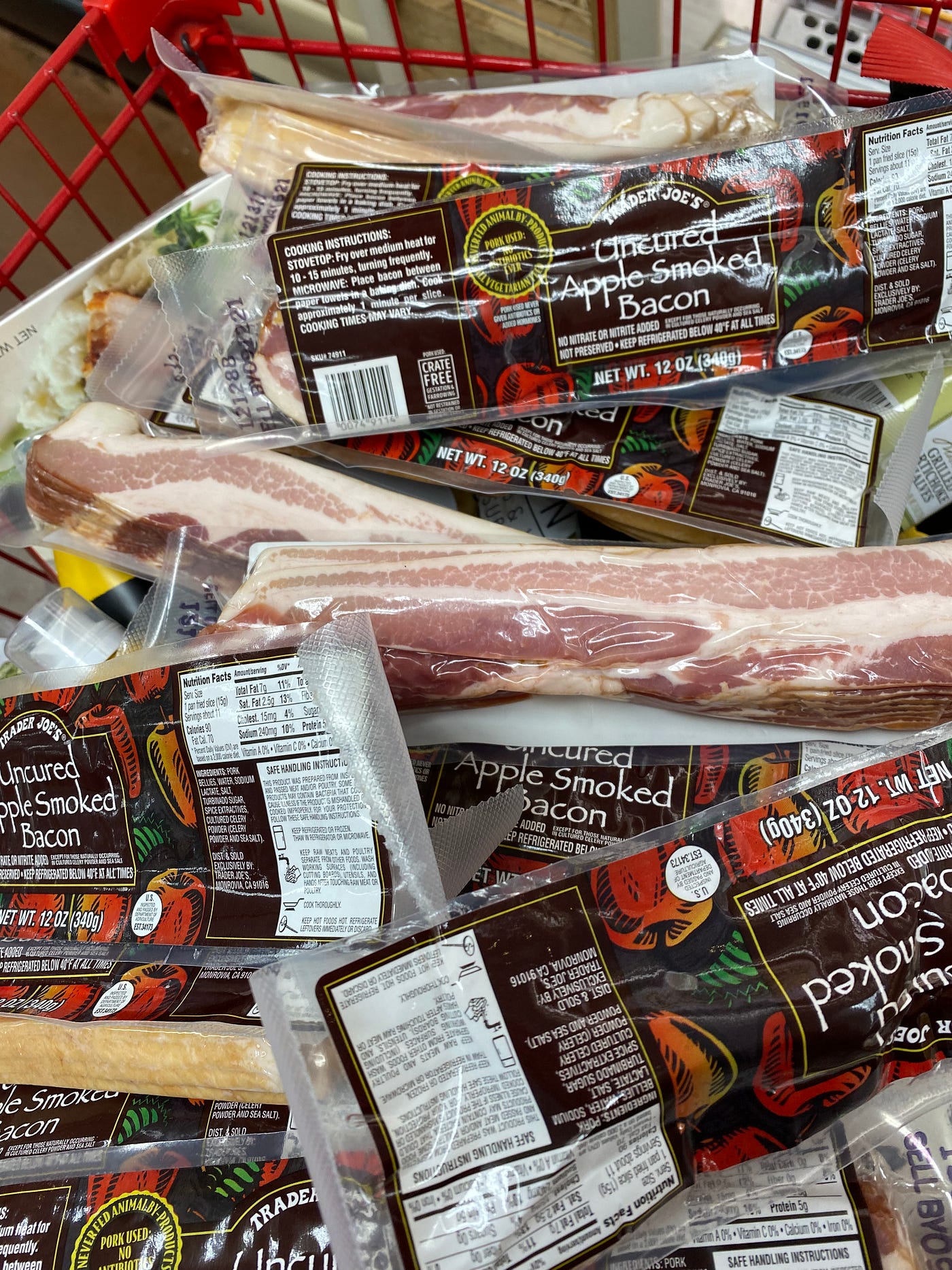 A very large amount of Trader Joe’s bacon in a shopping cart