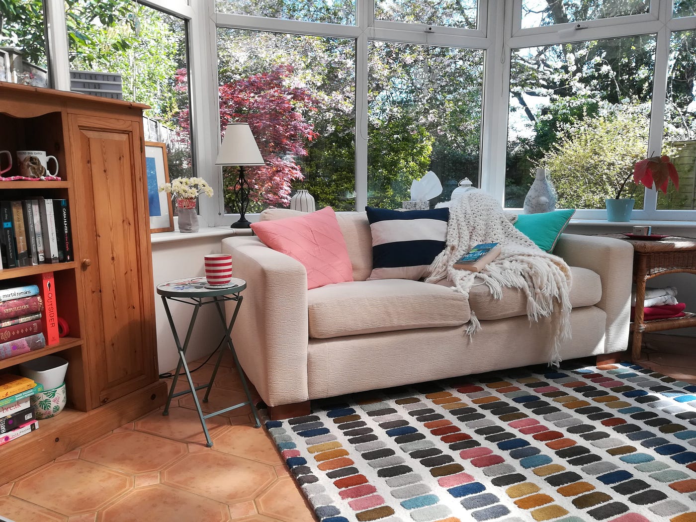 Conservatory with sofa, book and cup of tea