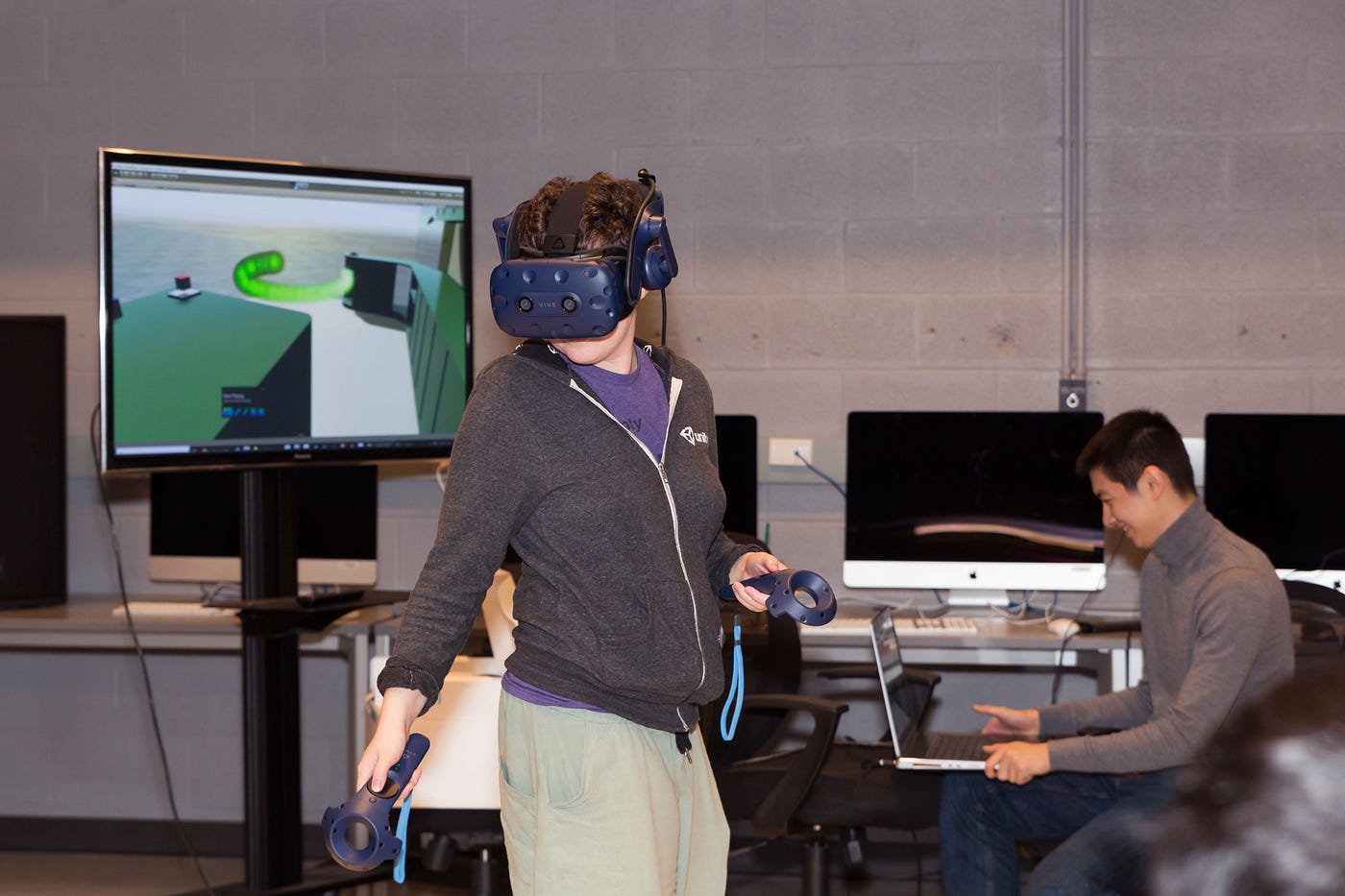 A UT Arts and Entertainment Technologies assistant professor wears a VR headset to try a Planet Texas 2050-inspired VR game.