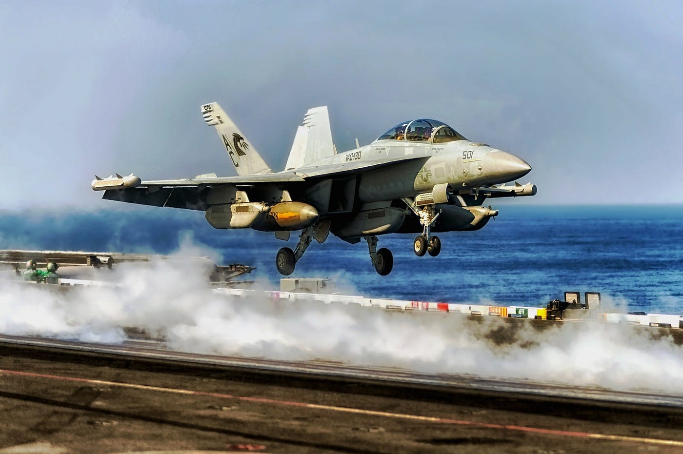 A Navy fighter jet taking off from an aircraft carrier
