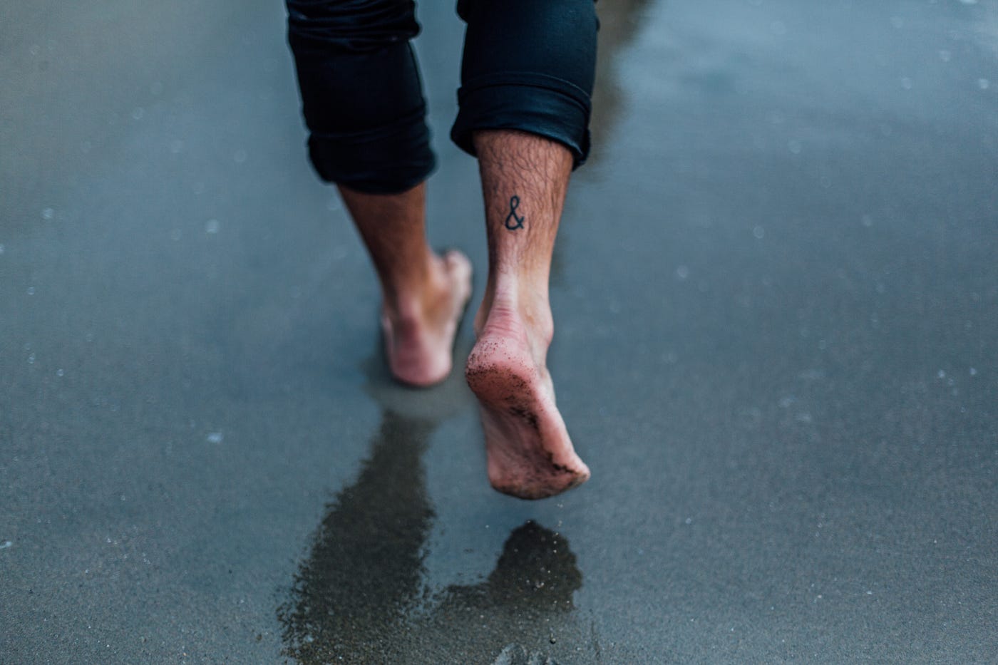 feet of man walking in the beach