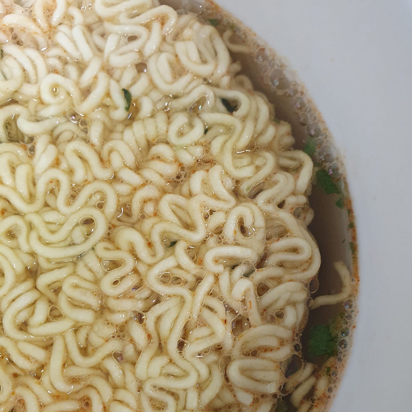 Boiling water filled up to the fill line in a cup of Samyang Ramen Gold.