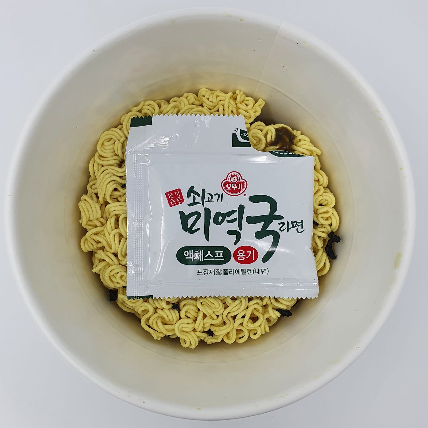 The liquid soup packet found inside a cup of Ottogi Sogogi Miyeokguk Ramen.