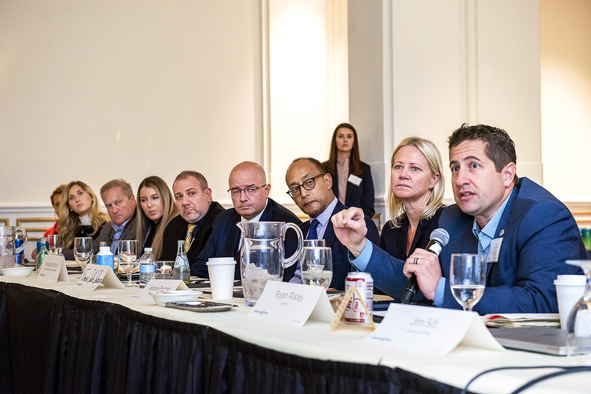 Kristie sits at a table with attendees of a government forum Operation Smile hosted.