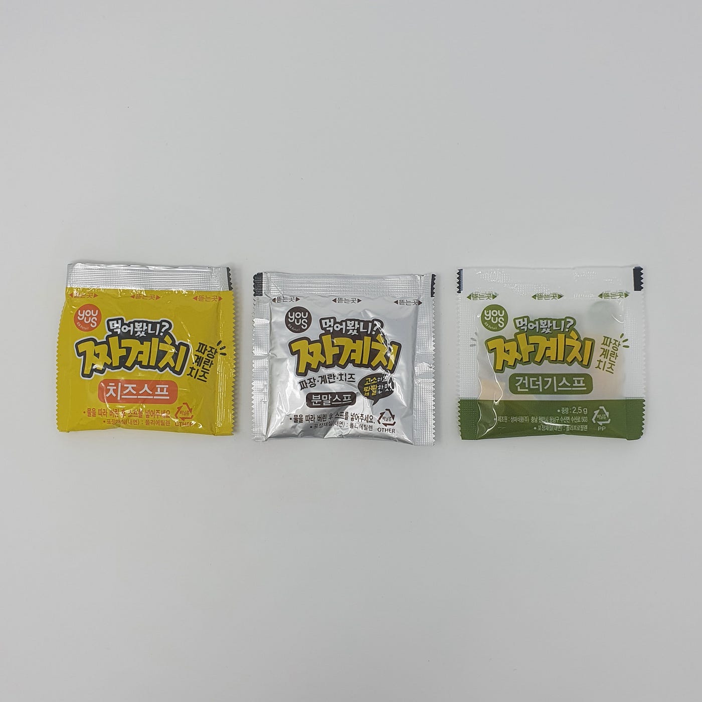 The three packets found inside a cup of YouUs Jjagyechi Instant Noodles.